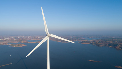 Aerial view of Windmill for electric power production and the city on background. Finland