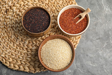 Flat lay composition with different types of quinoa on grey background