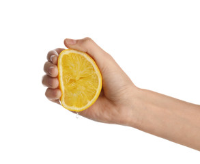 Woman squeezing fresh lemon juice isolated on white, closeup