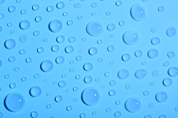 Water drops on color background, top view