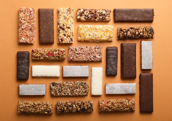 Flat lay composition with protein bars on color background