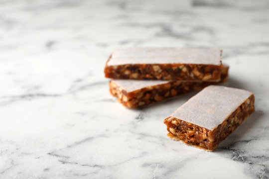 Tasty protein bars on marble table. Space for text