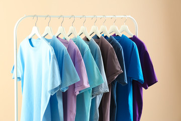 Men's clothes hanging on wardrobe rack against light background