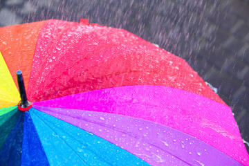 Bright color umbrella under rain outdoors, closeup
