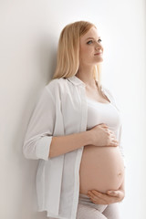 Portrait of beautiful pregnant woman on light background