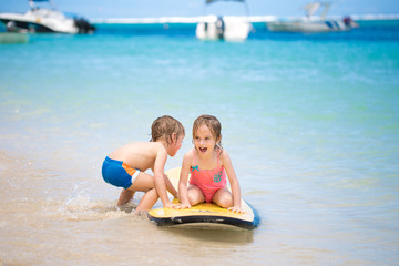 Twins brother and sister to have fun with surfing in the ocean