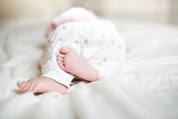 Cute little baby sleeping on bed at home. little baby feet