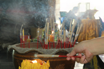 Lighted candle and incense for Buddha. Selective focus.