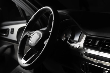 Fototapeta na wymiar Interior of luxury suv car with black leather steering wheel and shift gear. Alcantara cockpit seats and doors. Black dashboard.