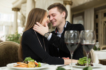 Beautiful young couple kissing in restaurant