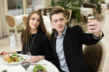 Beautiful couple taking selfie photo in a restaurant