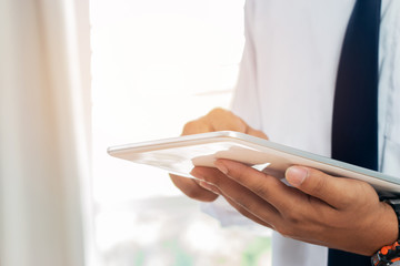 Online searching social networks by Smartphone Concept: Businessman stand using laptop computer...