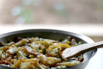 Lyonnaise potatoes are sliced pan-fried potatoes with onion, parsley, butter and garlic. Selective focus.