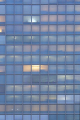 Obraz na płótnie Canvas Glass blue square Windows of facade modern city business building skyscraper. Modern apartment buildings in new neighborhood. Windows of a building, texture.