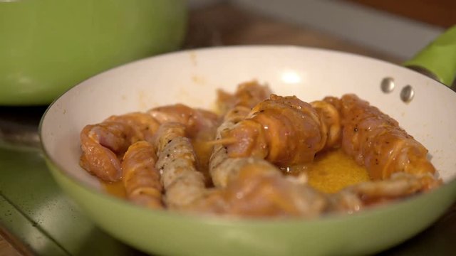 Cook a skewers of meat in pan