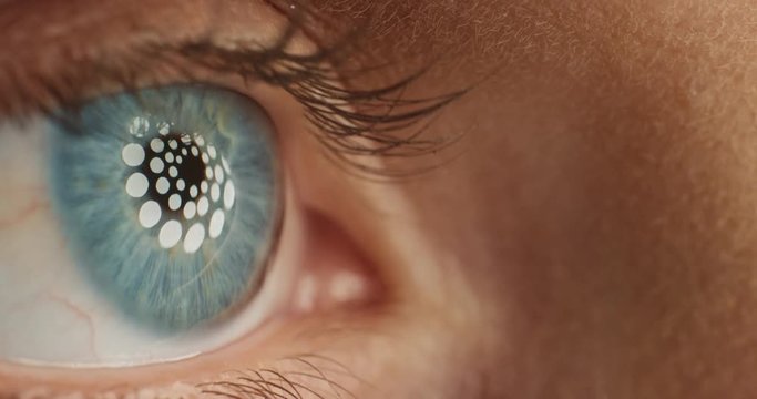 close up beautiful blue eye opening blinking with light reflecting on iris macro healthy eyesight surgery concept