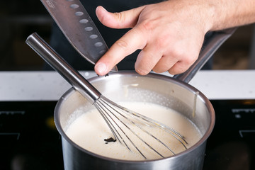 Chef prepairing tart filling, pouring vanilla beads