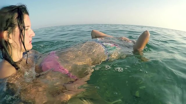 Teen girl save sister from drowning in sea at summer vacation, slow motion