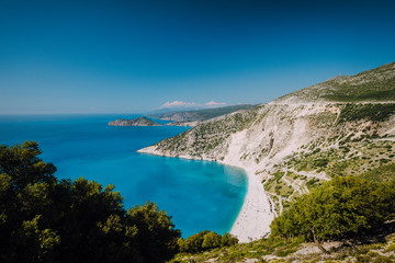 Fototapeta na wymiar Beautiful view of Myrtos beach in high tourist summer season. Myrtos is one of the famous beaches in the world and the Mediterranean sea located in Kefalonia island, Greece, Europe