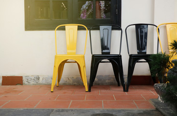 Yellow and black chair near the window at the outdoor hotel with light effect background