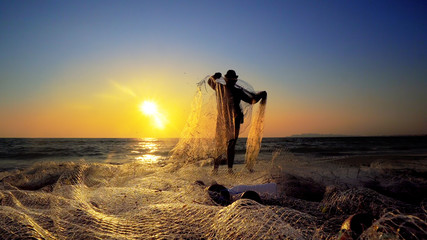 Sunset fishermans pulling net catching fish on ocean, cinematic steadicam shot