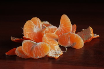 Orange peel mandarines on a dark background on a wooden table. Tropical fruits. Closeup for concept design.