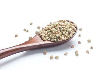 Organic buckwheat in a wooden spoon on white background