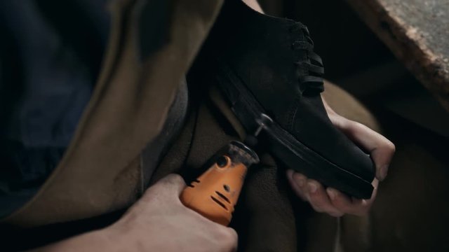 shoemaker makes shoes for men He polishes sole of shoe last handmade craft production factory leather boots