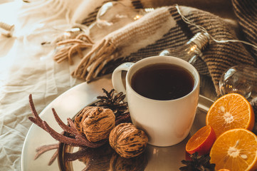 Christmas still life with cup with tea or coffee, cookies in the shape of snowflakes, oranges with christmas decorations and nuts