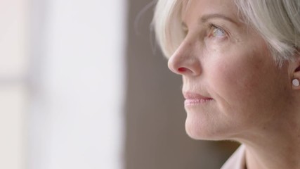 beautiful middle aged business woman contemplating retirement enjoying peaceful view looking out window healthy mature female relaxing at home thinking successful lifestyle milestone - Powered by Adobe