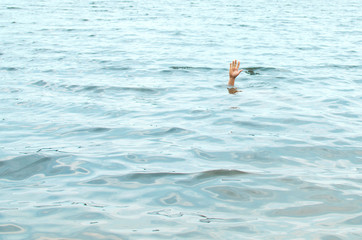 hand of a drowning man leaning out of the water