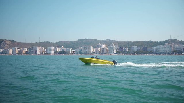 Motor boat sailing fast and pulling parasail parachute, tracking shot