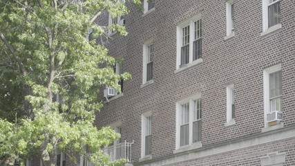Standard exterior establishing shot outside brick apartment building in city. Brooklyn style setting day time DX photo