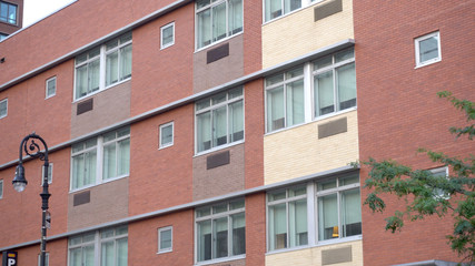 Exterior establishing shot of brick building day time. Apartment office school college dorm style architecture facade. Lock down DX image