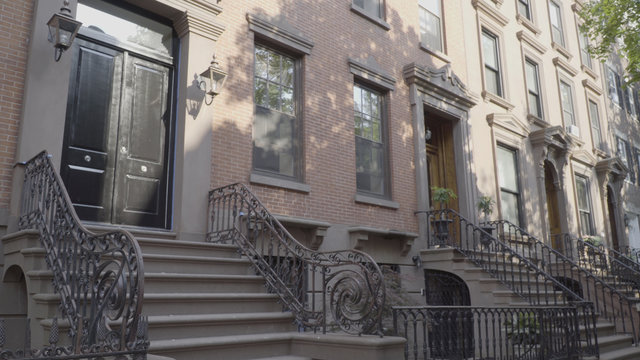 Wide exterior establishing shot outside typical generic Brooklyn style brownstone row of houses. Day time DX photo. Famous style architecture expensive luxury real estate living
