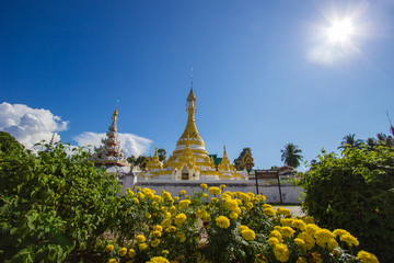 Wat Chong Klang,Mae Hong Son,northern Thailand on November 19,2017:Burmese-style white and golden chedi and 5-tier pyatthat with blue sky background