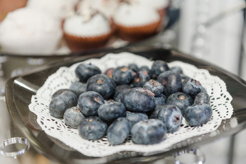 Fresh blueberries are lying on a plate. Ripe berry for dessert. Violet sweet berry closeup.