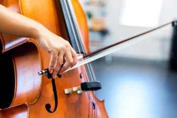 Close up of cello with bow in hands