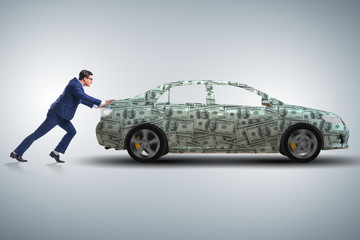 Businessman pushing car in business concept