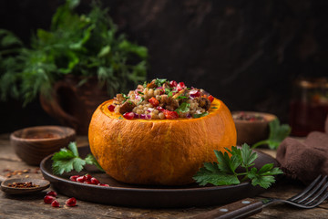 whole pumpkin stuffed with barley and vegetables, served with pomegranate and parsley