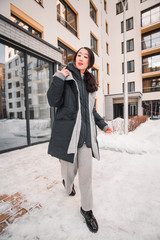 fashion outdoor photo of gorgeous sensual woman with black hair in elegant clothes  walking by winter city