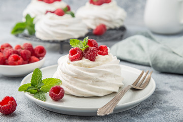 mini pavlova  meringue cakes with whipped cream and fresh raspberry