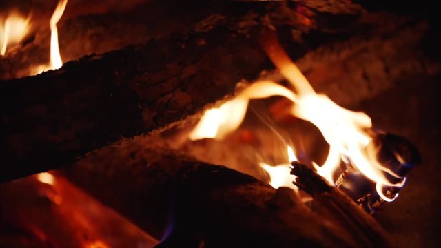 Close up and slow motion view of burning firewoods, firecamp with sparks