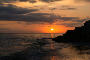 Beautiful photo of sunset on the Gulf of Mexico with the silhouette of a rock outcropping.