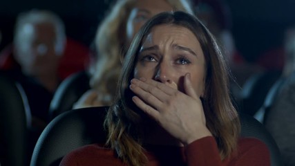 Tearful woman watching a sad and emotional movie