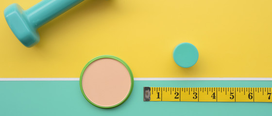 Fitness concept dumbbell and measuring tape for background