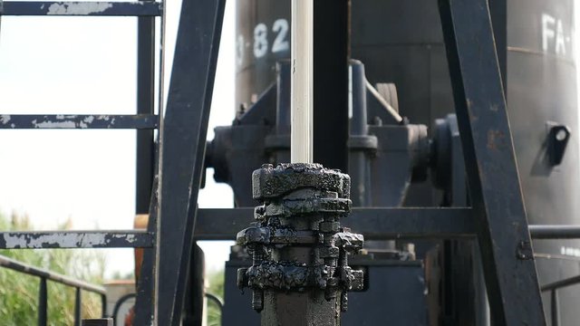 Big dynamo motor machine set working with belt over green garden outdoor background part of crude oil lifting pump - moving mechanical part of machine industrial concept