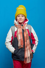 school girl with backpack wearing scarf with hat.