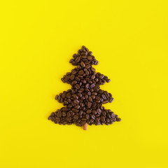 Winter composition with Christmas tree made by coffee beans and decorated cinnamon stick on a yellow background, flat lay. Greeting card for New Year with copy space.