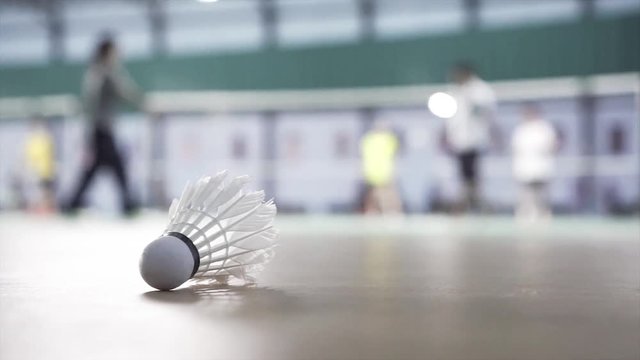 Close up shuttlecocks on badminton courts with players competing.